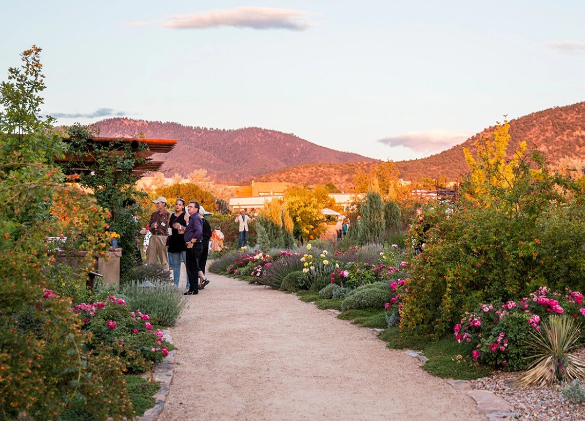 garden Visitors walking a garden path lined with flowering shrubs